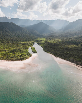Aerial view of lush Daintree Rainforest with serene Noah Creek and majestic mountains, Cape Tribulation, Australia.