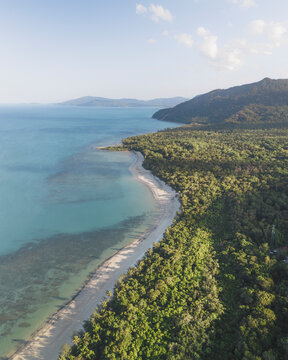 Aerial view of beautiful Myall Beach and lush Daintree Rainforest along the coastline, Cape Tribulation, Australia.