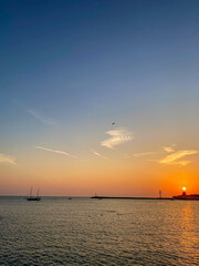 Beautiful sunset over the sea with sailboats in the background