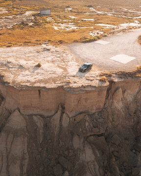 Aerial view of barren rock formations and a scenic road with a Japanese car in the arid landscape, Cortes, Spain.