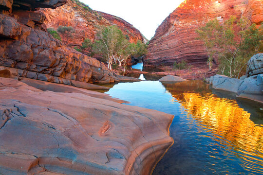 Aerial view of hamersley gorge with dramatic rock formations and tranquil water reflections, karijini national park, pilbara region, australia.