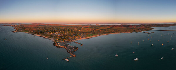 Aerial view of tranquil sunset over the beautiful Dampier foreshore with boats in the harbor, Karratha, Western Australia.