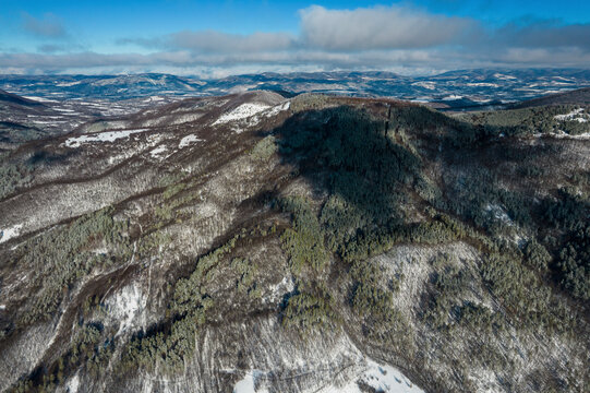 Aerial view of snowy balkan mountains with lush forests and cloudy sky, Elena, Bulgaria.