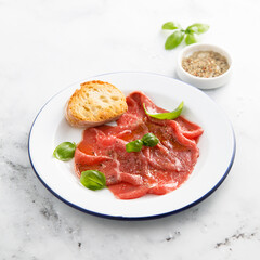 Traditional beef carpaccio with salt and pepper