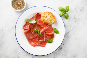 Traditional beef carpaccio with salt and pepper