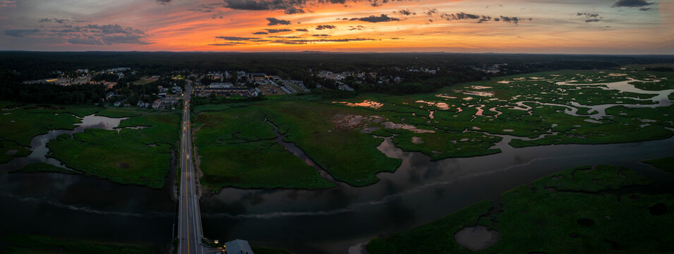 Aerial view of serene sunset over marsh and estuary with winding river and mountains, Wells, Maine, United States.