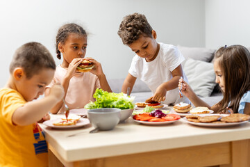 Children enjoying lunch around a table with salads.