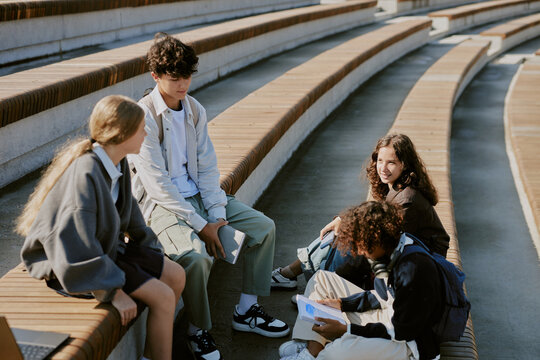 High angle shot of biracial teens resting together after school at stadium - Powered by Adobe