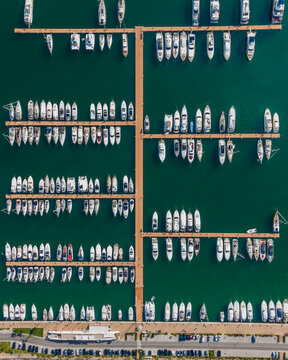Aerial view of Marina d'Arechi port, a big pontoon with sailing yacht along the shoreline, Salerno, Italy.