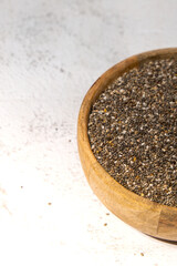 Chia seeds in wooden bowl. Healthy superfood rich in Omega 3 fatty acids. Dry healthy natural ingredient. Chia grains are falling