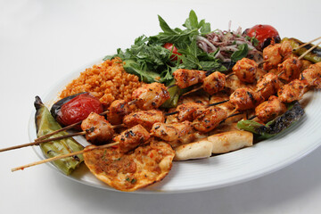 Chicken shish kebab on a serving plate.
Served with salad and rice
