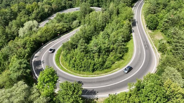 A short flight past a winding mountain road with cars passing by. Mavic 3