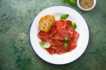 Traditional beef carpaccio with salt and pepper