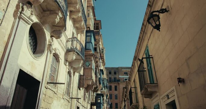 Architecture of touristic old streets in Valletta on the island of Malta. Historic balconies and old houses in the center of a Mediterranean tourist town, urban landscape. High quality 4k footage