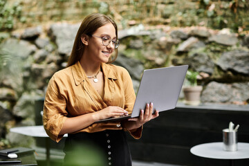 A young woman engages in her daily routine, delightfully focused on her laptop in a vibrant cafe.