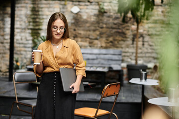 In a cozy cafe, a young woman confidently balances her drink and laptop, showcasing her vibrant daily life.