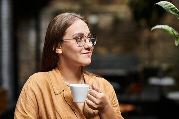 A young woman sips her coffee, embracing a moment of relaxation in a charming cafe.