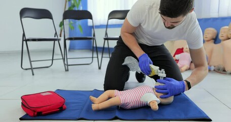CPR training medical procedure. Demonstration of breast compression on CPR baby doll in class. Medical courses.