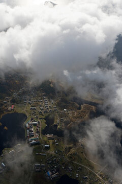 Aerial view of a tranquil village with scenic homes by a beautiful lake under cloudy skies, Onega Bay, Russia.