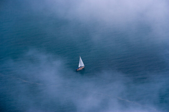 Aerial view of serene sailboats on calm blue sea with clouds, Krasnodar Territory, Russia.