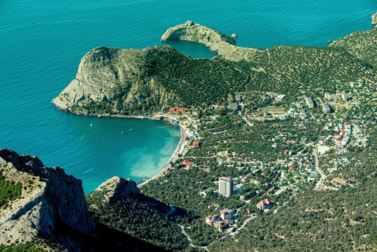 Aerial view of beautiful coastline and serene beach with village and mountains, Novyi Svit, Russia.