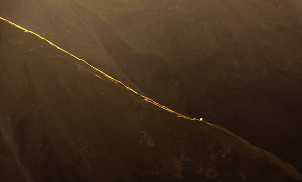 Aerial view of majestic mountains and a scenic trail at sunset, Krasnaya Polyana, Russia.