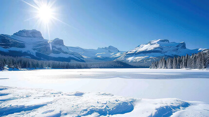 Frozen lake with snow-covered mountains in the background under a clear, bright winter sky, creating a picturesque winter scene.