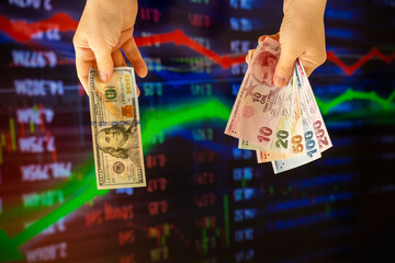 American dollar and Turkish lira on woman's hand and stock market screen, money chart background