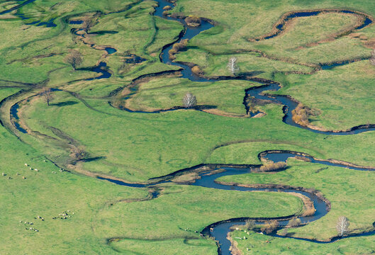 Aerial view of meandering river through lush green wetlands with scenic grassland and trees, Bashkortostan Republic, Russia.
