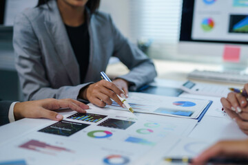 Business team analyzing financial data using charts and graphs, discussing strategies and performance in a collaborative office environment
