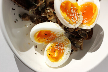 Soft Boiled Eggs with Bright Yolks on Toast with Roasted Mushrooms. Breakfast Closeup.