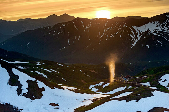 Aerial view of mutnovsky volcano at sunset with snow-covered mountains, Kamchatka peninsula, Russia.