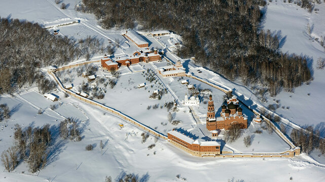 Aerial view of Assumption Saint George Monastery surrounded by a snowy landscape and forest, Bashkortostan Republic, Russia.