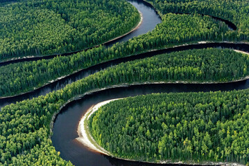 Aerial view of winding river through lush siberian taiga forest, khanty mansi autonomous okrug, russia.