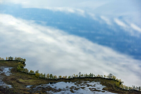Aerial view of serene Numto Lake surrounded by trees and clouds, Khanty Mansi Autonomous Okrug, Russia.
