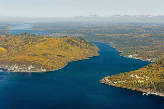 Aerial view of baikal lake and angara river surrounded by mountains and forest in autumn colors, Irkutsk, Russia.