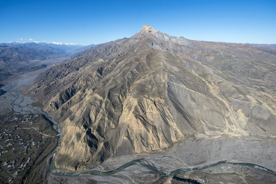 Aerial view of a breathtaking mountain village surrounded by majestic peaks and a tranquil valley, Kurush, Dagestan Republic, Russia.