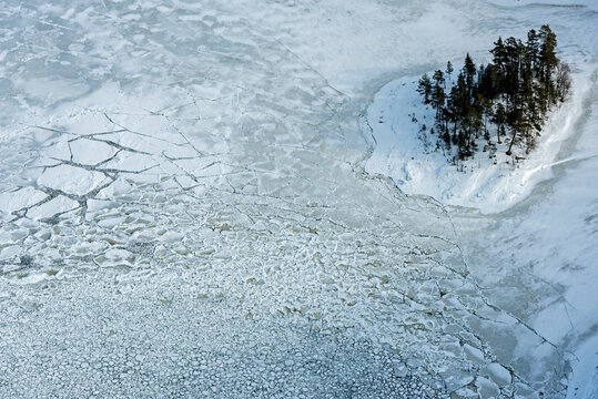 Aerial view of frozen Lake Ladoga with snowy textures and serene wilderness, Karelia Republic, Russia.