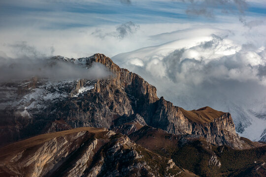 Aerial view of majestic snowy mountains under dramatic clouds, Tsrau, Russia. - Powered by Adobe