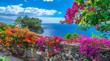 Fototapeta premium : A picturesque garden with colorful bougainvillea climbing over a stone wall, under a flawless blue sky, the sea glistening in the background