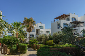 Fototapeta premium Charming resort complex surrounded by lush greenery in a sunny location during midday.