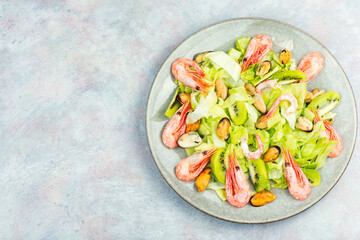 Seafood salad with shrimps and mussels on plate.