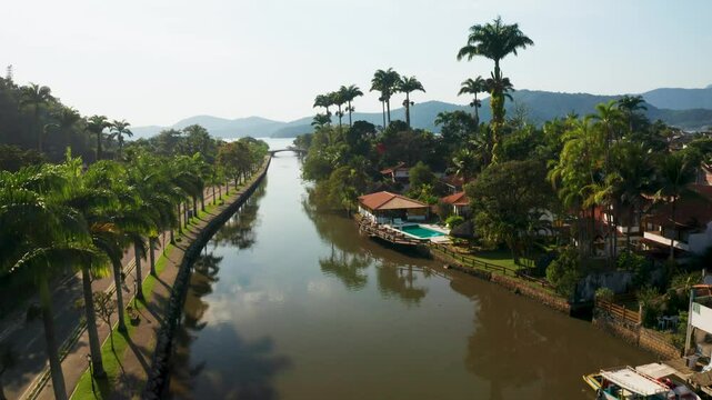 Aerial view of the historical center with picturesque houses and lush palm trees along the river, Paraty, Brazil.