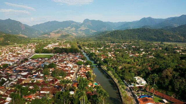 Aerial view of the picturesque historical center with a river surrounded by mountains and greenery, Paraty, Brazil.