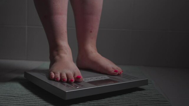 Unrecognisable overweighted woman getting on the scale