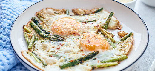 Fried eggs with asparagus and grated cheese. Breakfast concept.
