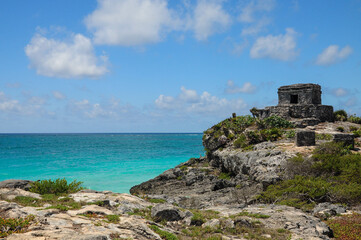 Tulum ruins overlook turquoise Caribbean Sea under bright blue sky