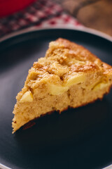 Slice of homemade apple biscuit pie type charlotte on black plate