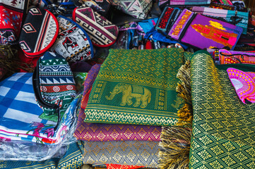 Colorful bags and various textiles on the counter at a street bazaar in Vietnam in Asia