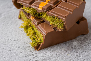 Dubai Chocolate bar with green kadayif and peanut butter on white stone table